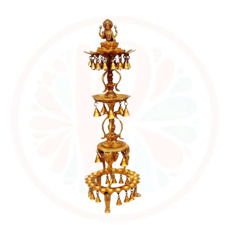 a tall gold candle holder with bells and bells