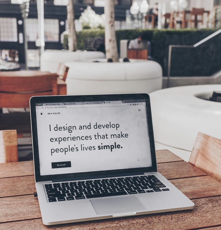 szürke Laptop egy fa asztalon felnyitva