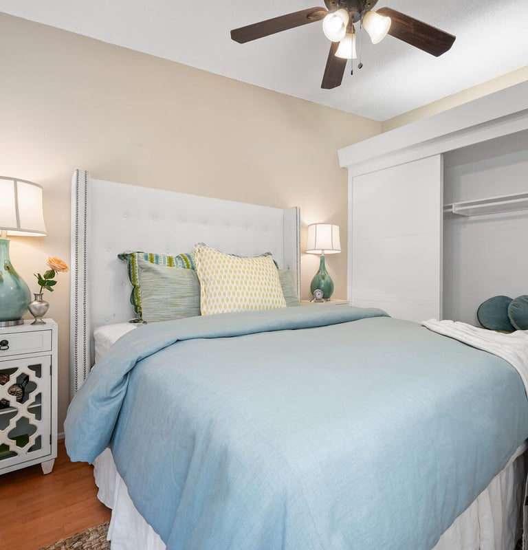 a bedroom with a ceiling fan, luxurios bed, pillows and nice bedding