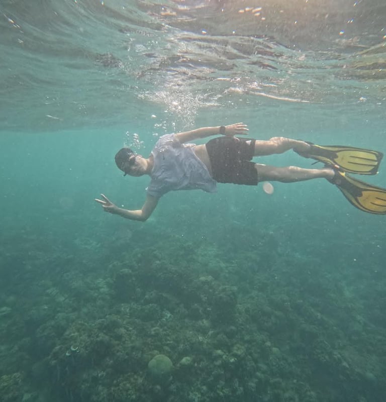 a man swimming in the ocean with a scuba diver