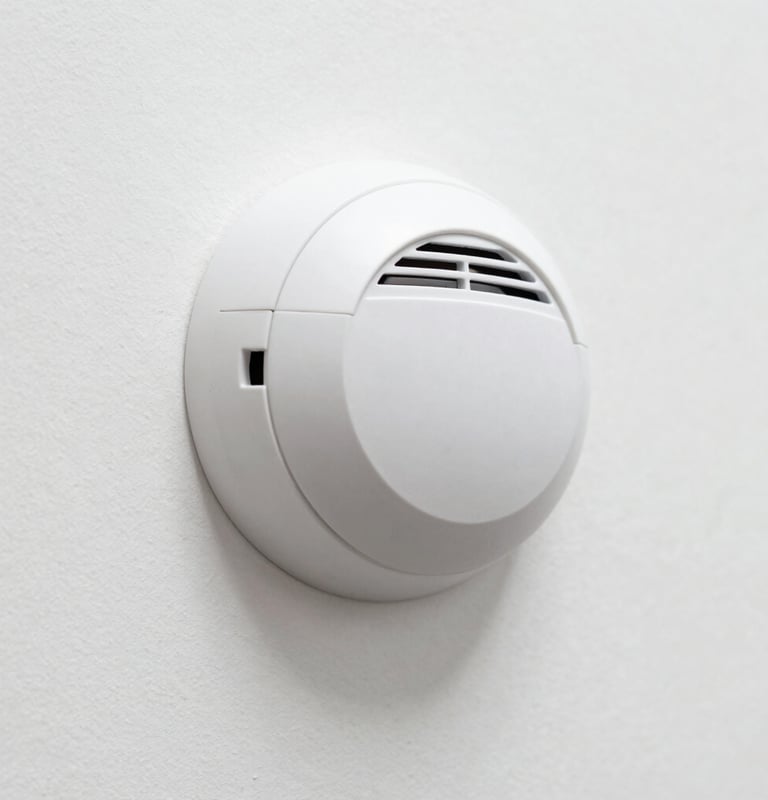white smoke co detector on white wall