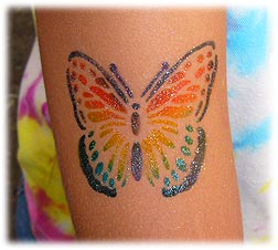 a butterfly glitter tattoo on a woman's arm