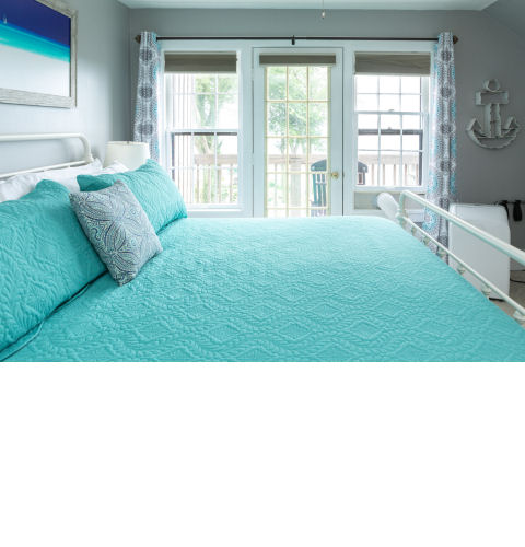 South Cliff Inn's Sunset room, with a glimpse of the lake view from the bedroom and balcony