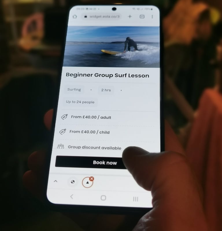 A mobile phone displaying a booking page with someone clicking book now