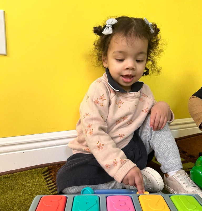 a young girl sitting on the floor with a toy-FANTASTIC LAND LEARNING CENTER