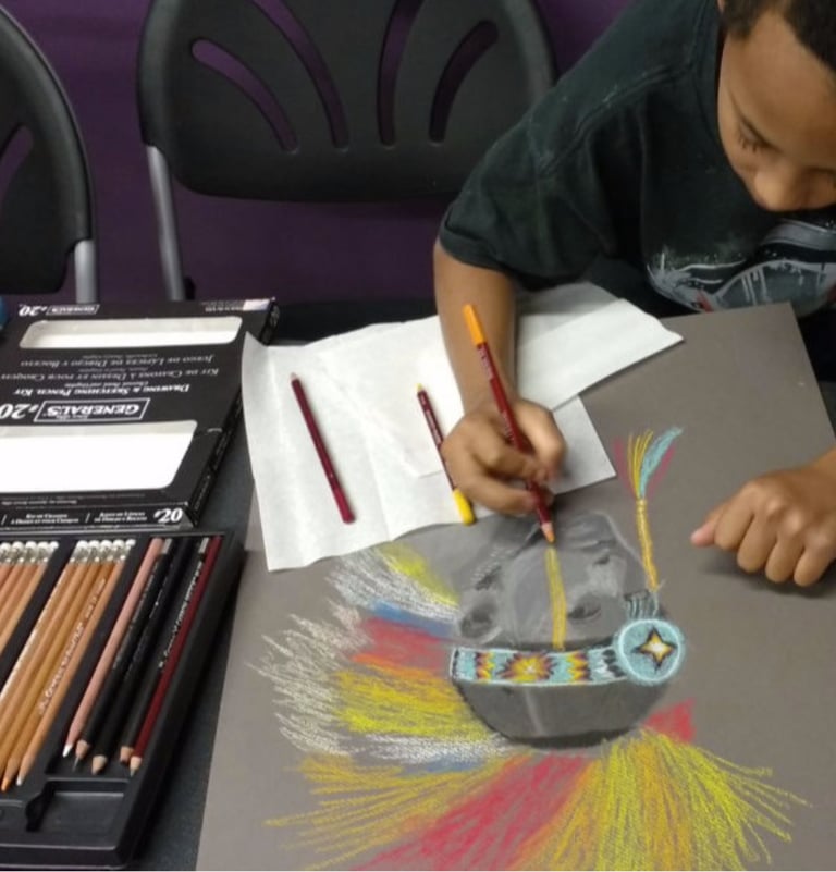 a young boy is drawing a colorful picture of a native american