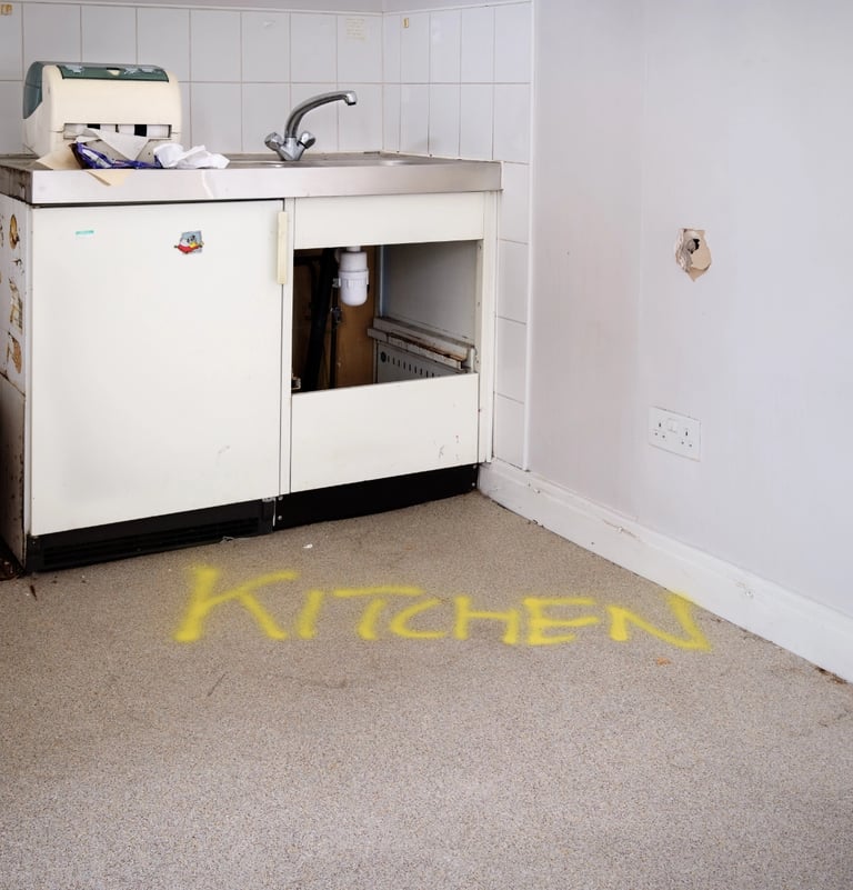Disused kitchen with word kitchen sprayed on floor