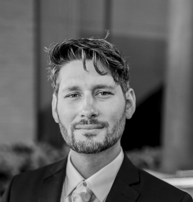 a man in a suit and tie standing in front of a building