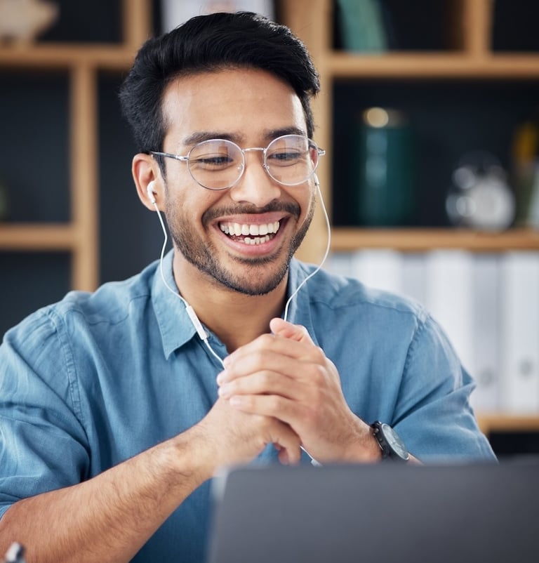 a man with glasses and headphones on his laptop