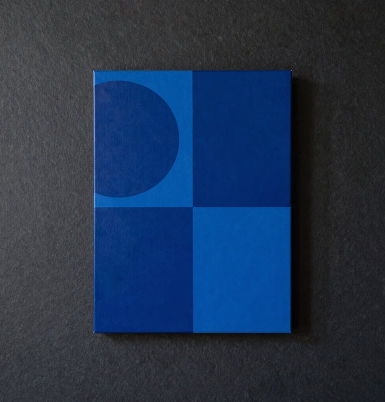 A portrait-oriented photograph of a finished artwork hanging in a high-end International / Urban Art Scene loft, featuring bold monochromatic blue shapes against a deep charcoal slate background.