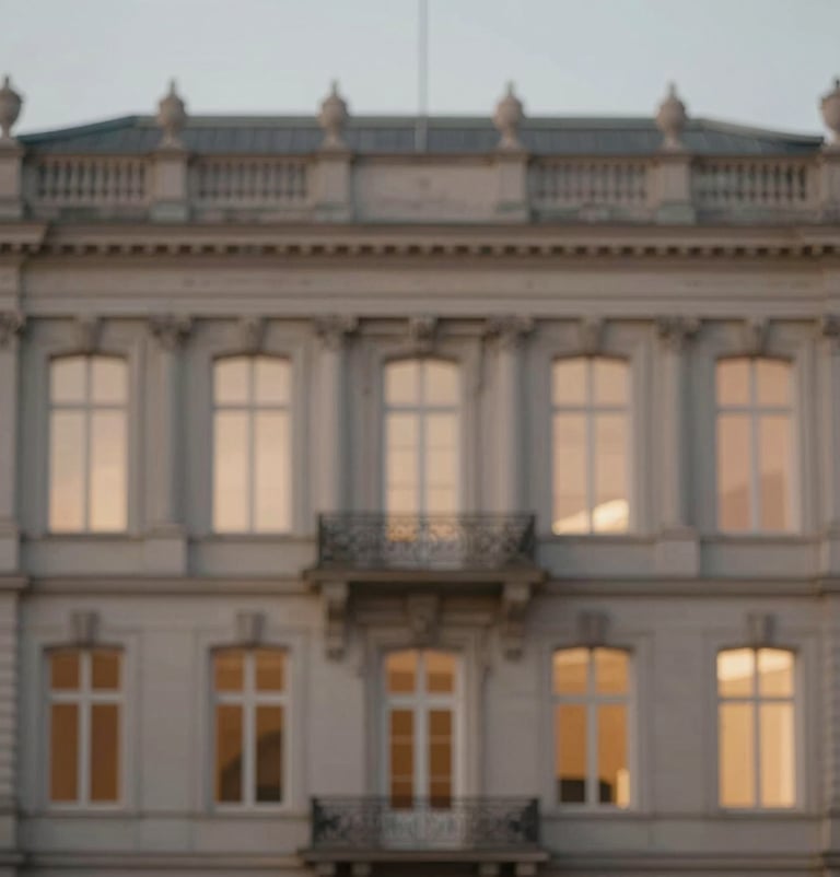 Elegant outdoor shot of a historical building facade at dusk. Soft #6B625E tones and warm #F5F4F0 lighting in the windows. Sophisticated, timeless elegance. Minimalist framing.