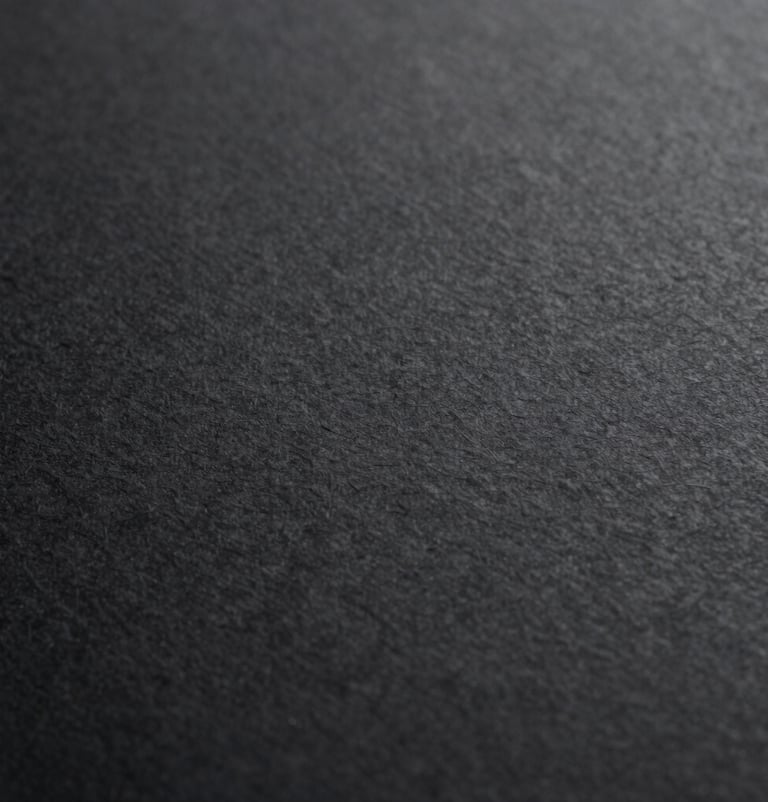An abstract macro shot of high-quality paper texture with a subtle emboss, monochromatic black and dark grey tones, representing artisanal craftsmanship and premium quality.