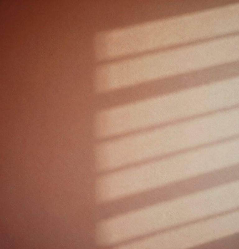 A conceptual, artistic photograph of soft light patterns reflecting off a studio wall. The colors blend from warm terracotta to soft sand, creating a dreamlike, sophisticated visual representation of music.