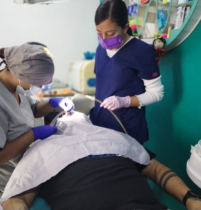 Dentista profesional y asistente realizando un procedimiento dental a un paciente en clínica