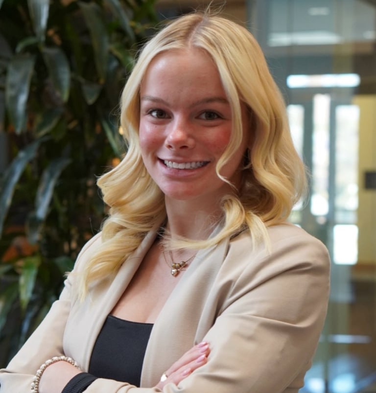 Formal headshot of Whitney with clean lighting and a poised, professional look.