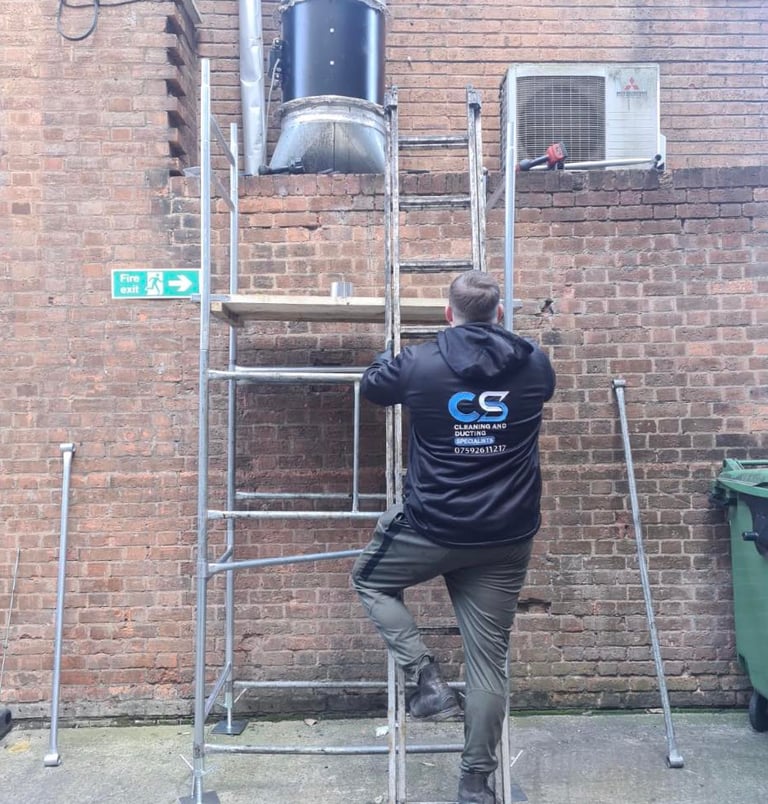 a man in cs cleaning and ducting company workwear fixing ducting