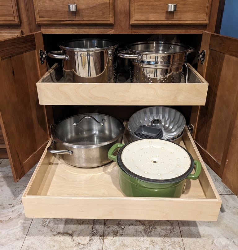 Kitchen cupboard pullouts holding pots and pans.