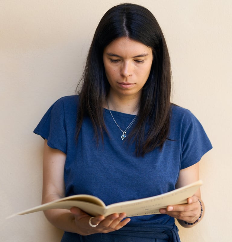 a woman in a blue dress is reading a book