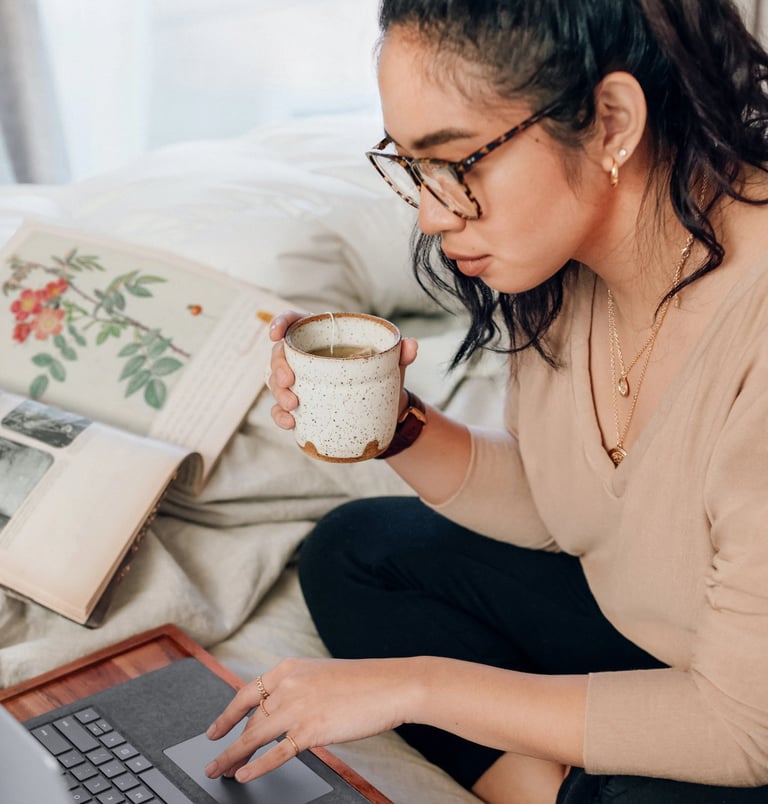 Woman drinking tea in front of computer