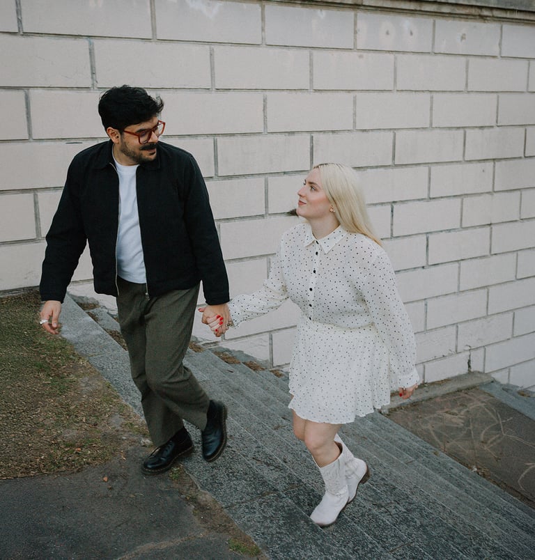 Pareja tomada de la mano subiendo una escalera