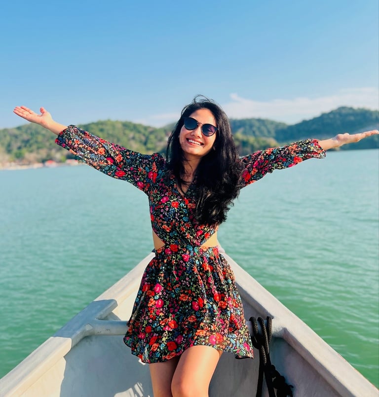 a woman in a dress and sunglasses on a boat
