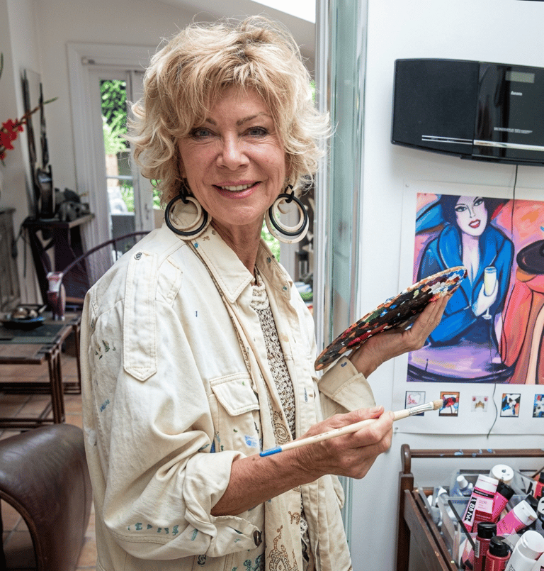 Portrait de Patricia Pierrard, artiste peintre expressionniste, avec palette et pinceau dans atelier