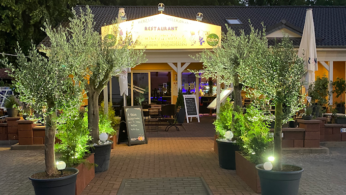 a restaurant with a large umbrella and potted plants