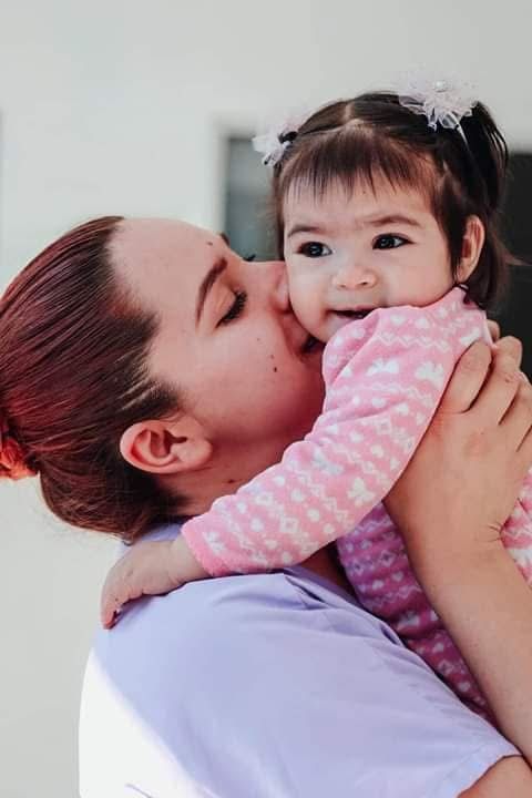 Una madre besando a su bebé sonriente