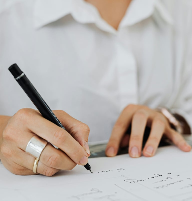 Kobieta prowadząca notatki czarnym długopisem. Pokazanie profesjonalizmu biura.