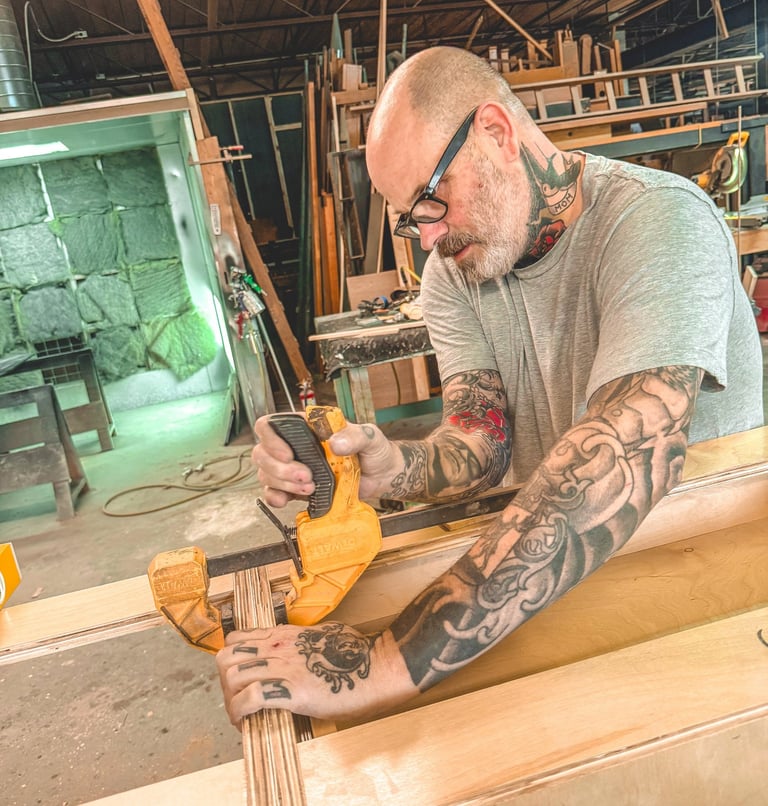 Master craftsman creating artisan woodwork in a Detroit workshop.