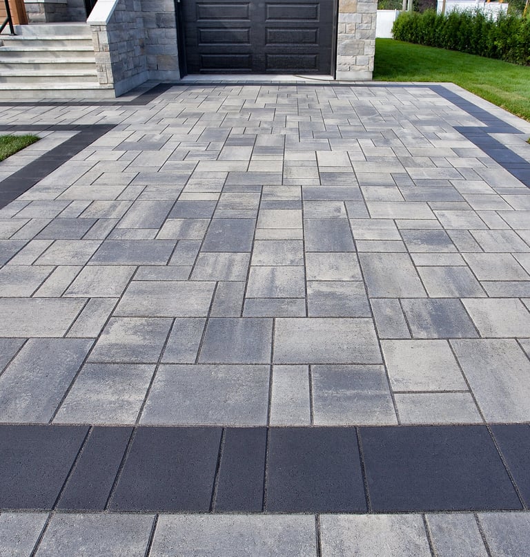 Modern staggered ashlar concrete paver driveway with dark charcoal border at a luxury Sarasota home