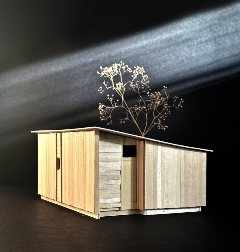 Handcrafted basswood architectural model of a modern cabin design against a dark background.