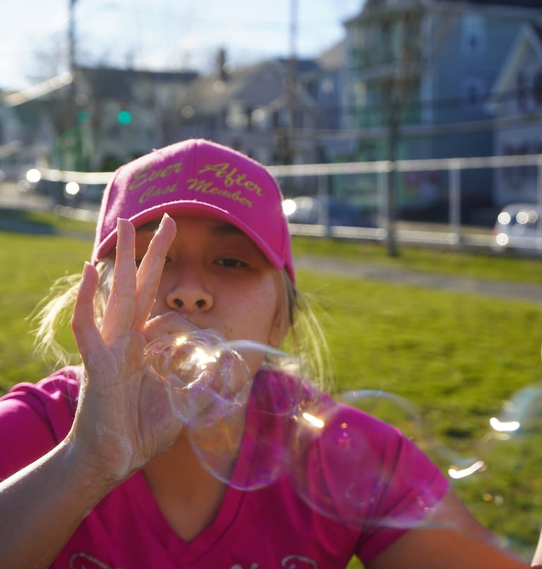 Bubble attendant blows bubbles through their fingers