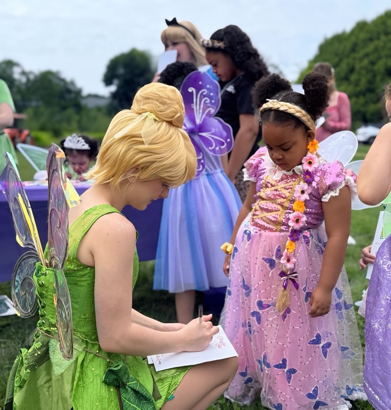 Tinker Bell signs and autograph for a child