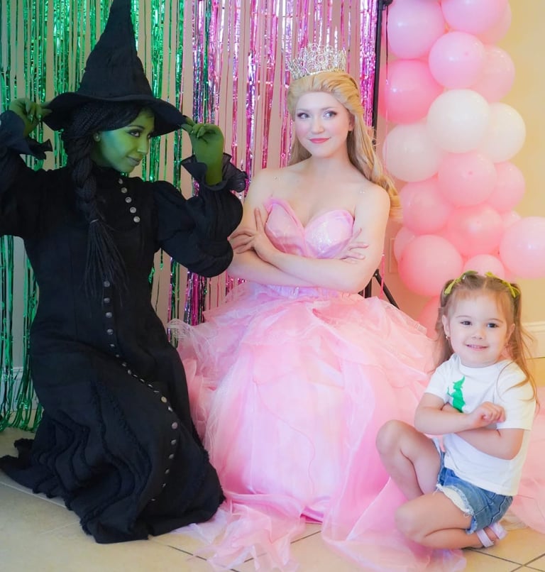 Elphaba and Glind pose with a child