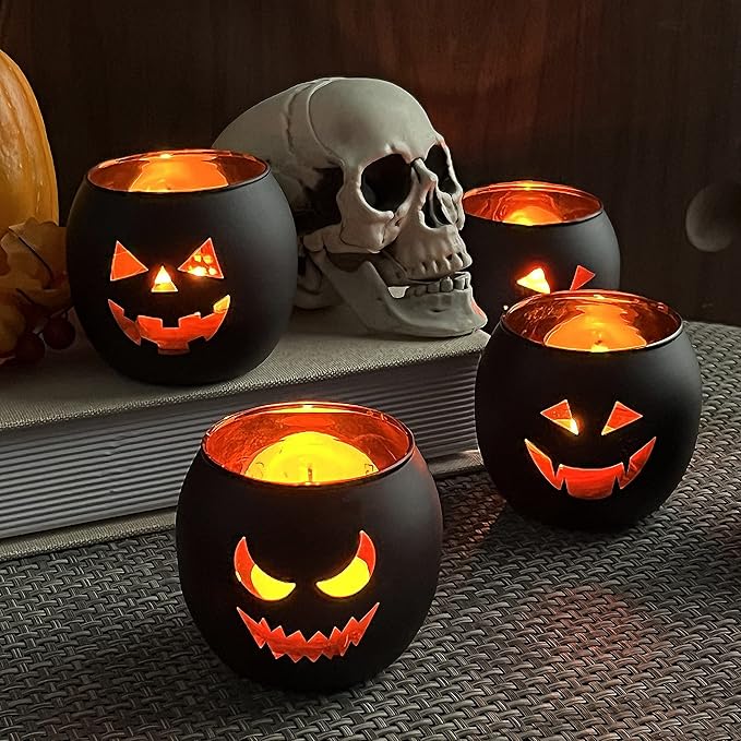 Set of black Halloween candle holders with glowing jack-o’-lantern faces, displayed beside a realist