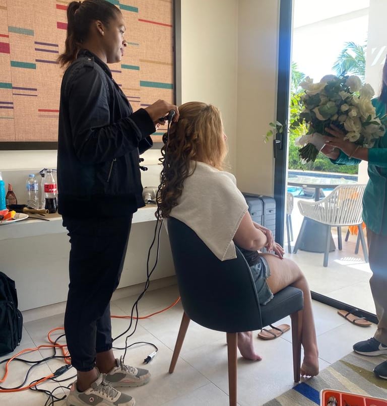 Deya Ventura bridal hair stylist curling a bride’s hair during wedding day preparations in Punta Cana, Dominican Republic