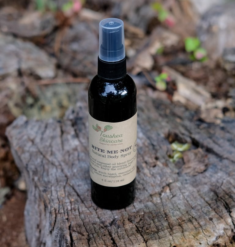 black spray bottle of liquid on a tree stump