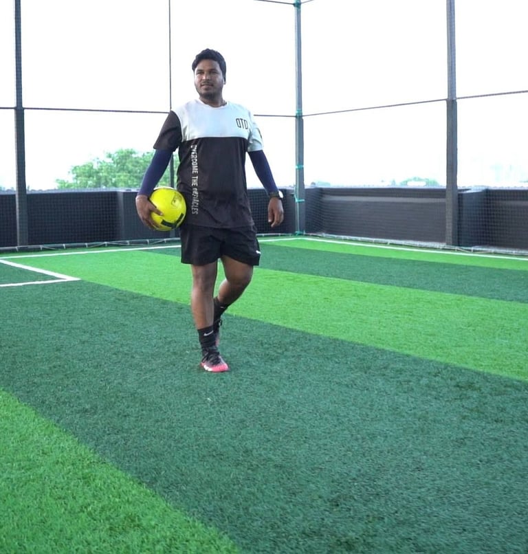a man in a black shirt and shorts playing soccer