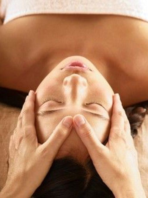 dedos pulgares sobre la frente para empezar masaje facial