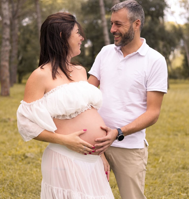 Sessió de fotos d'embaràs d'una parella amb dona embarassada en entorn natural exterior