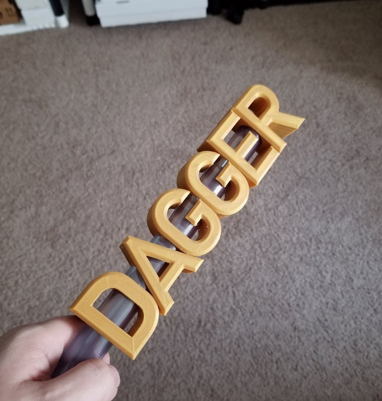 A 3d printed dagger with the blade forming the word dagger