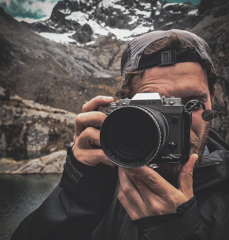 Fotografia di Marco Maggini mentre tiene in mano la macchina fotografica in montagna