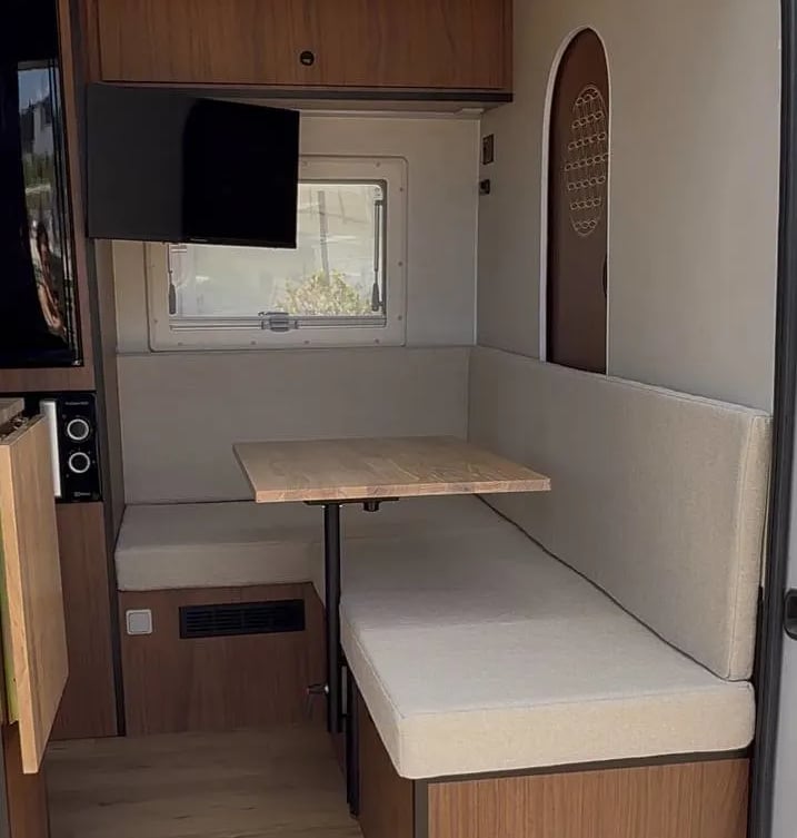 Una furgoneta con un sofá y una mesa en la parte trasera.
