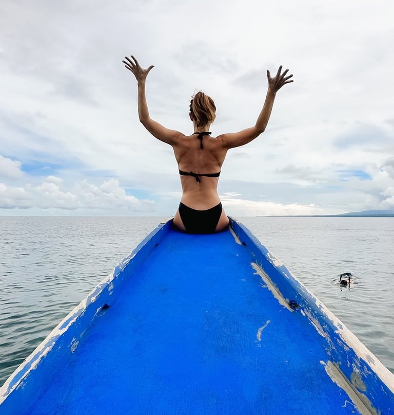 a man sitting on a boat in the ocean