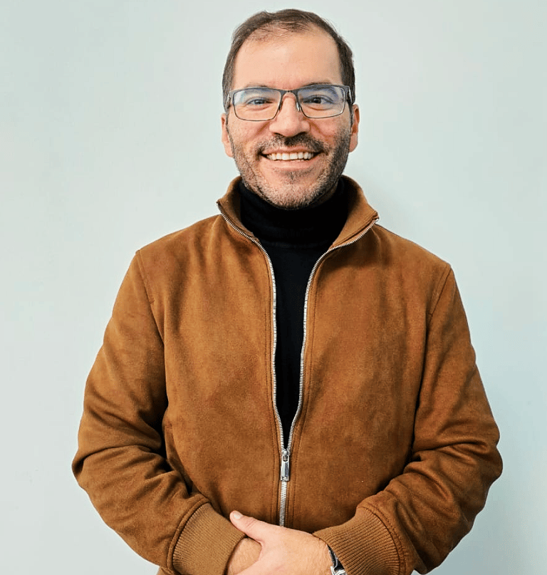 a man in a brown jacket and glasses