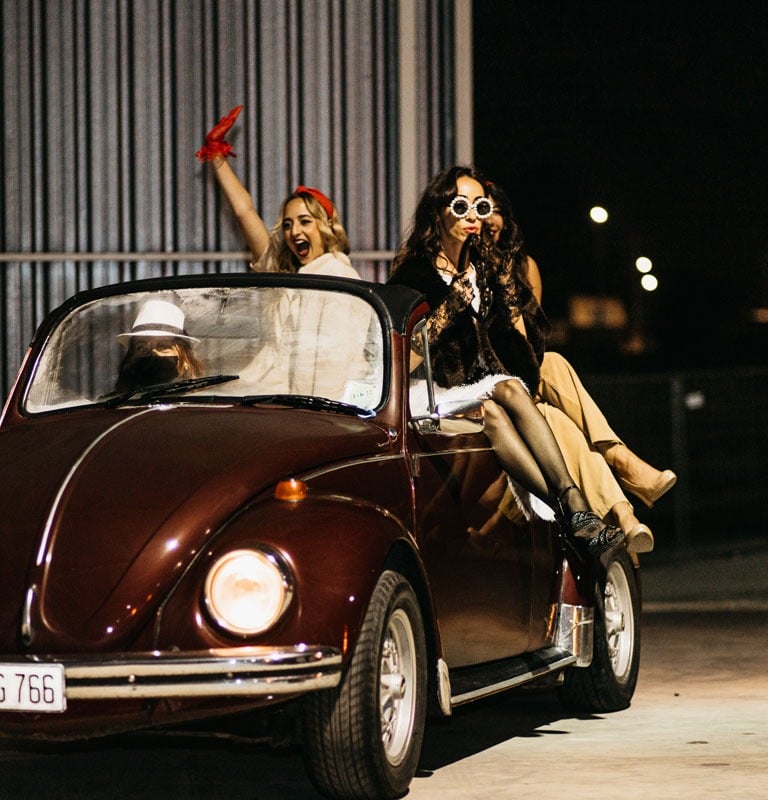 a group of dancers entering the venue in a vintage car during an event photoshoot in Malta