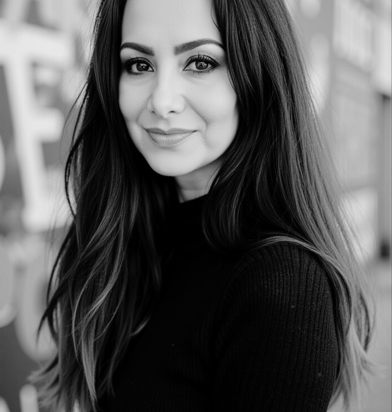 LVF is a beautiful woman with long brown hair standing in front of a colorful mural wall.