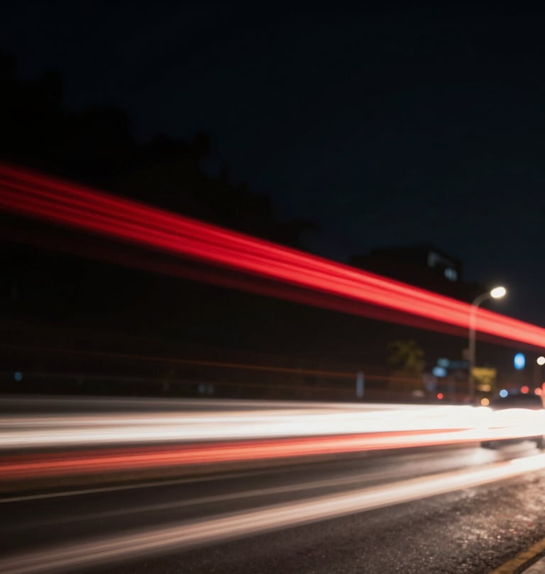 A blurred motion shot of city lights at night, dominated by deep black backgrounds and streaks of deep red and off-white light, suggesting speed and high production value.