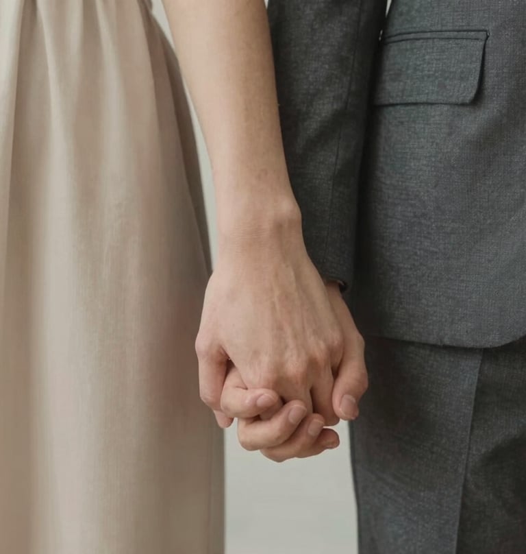 Detail shot of a couple's hands intertwined, focusing on the connection and texture of the fabrics in soft beige #E0DCD9 and dark gray #3D3A38, minimalist and intimate.